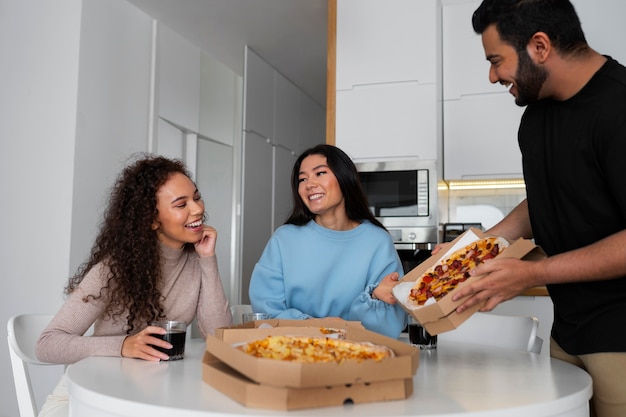 Foto gratuita amigos comiendo pizza en casa juntos