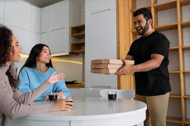 Amigos comiendo pizza en casa juntos