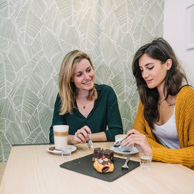 Foto gratuita amigos comiendo postre en café