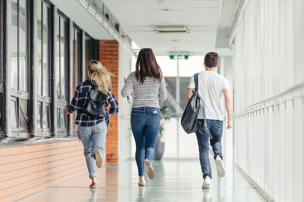 Amigos corriendo en la sala de la universidad