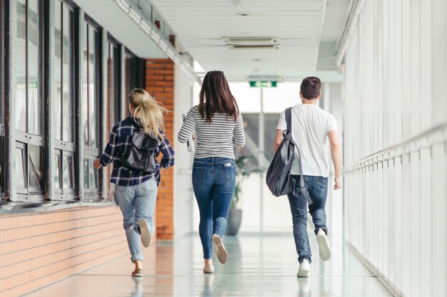 Amigos corriendo en la sala de la universidad