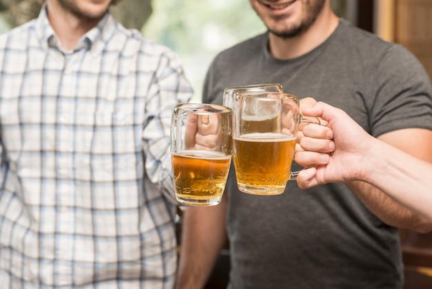 Amigos de la cosecha que tintinean tazas en la barra