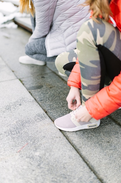 Foto gratuita amigos de cultivos atando cordones en el camino