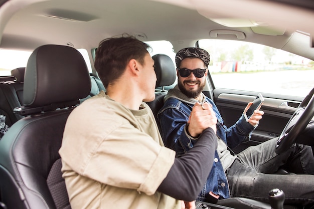 Amigos dándose la mano en el coche