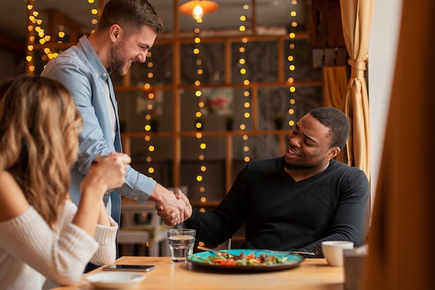 Amigos dándose la mano en el restaurante