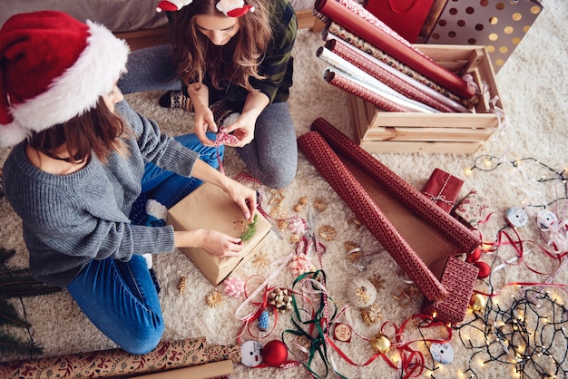 Amigos decorando un regalo de Navidad