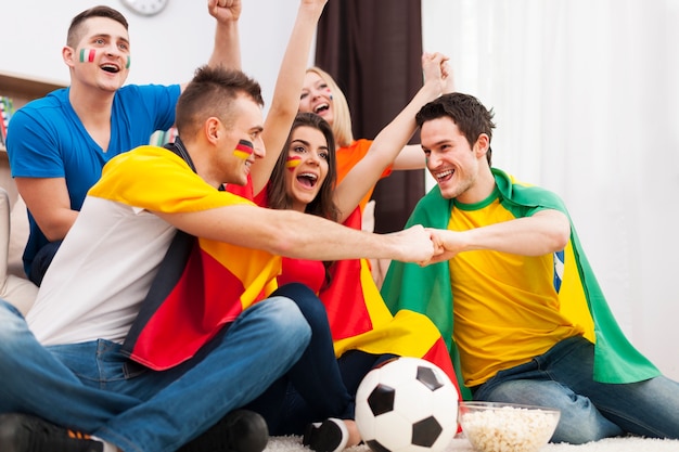 Amigos de diferentes naciones que apoyan al equipo de fútbol.