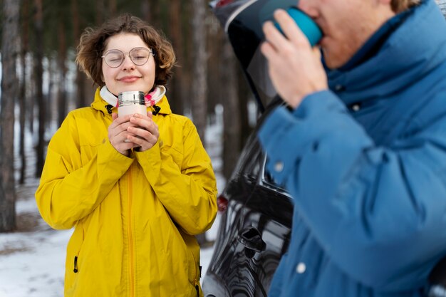 Amigos disfrutando de una bebida caliente durante un viaje de invierno