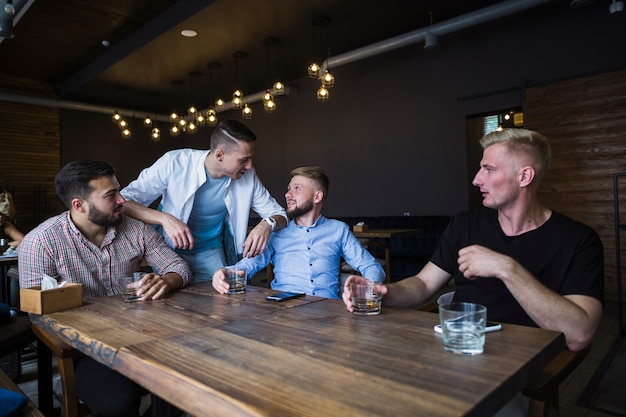 Foto gratuita amigos disfrutando de las bebidas en el bar