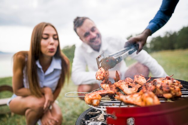 Amigos disfrutando de la carne asada en barbacoa