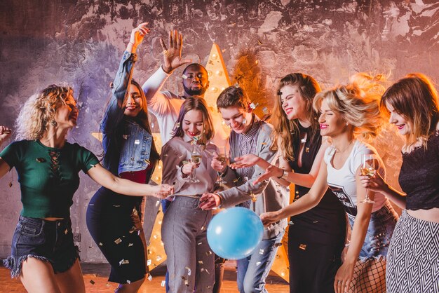 Amigos disfrutando de fiesta con confeti y globos