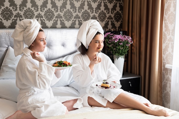 Amigos disfrutando de su día de spa con comida deliciosa.