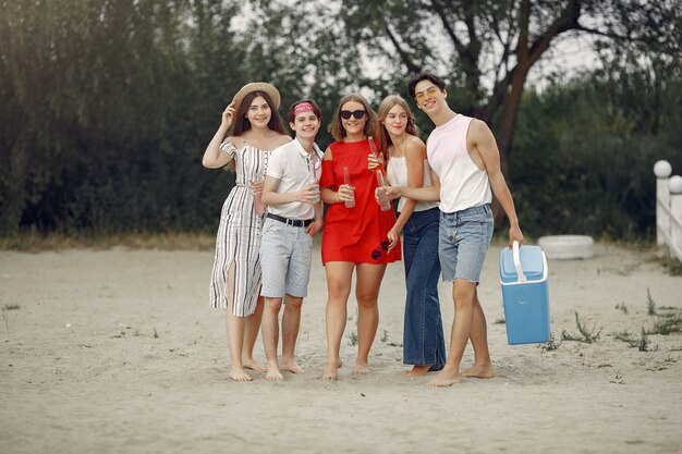 Los amigos se divierten en la playa con bebidas