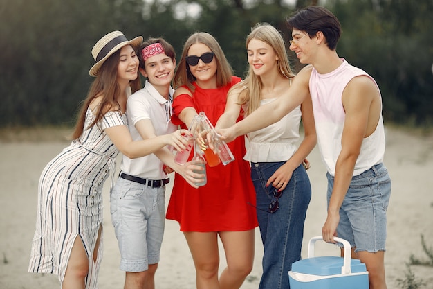 Los amigos se divierten en la playa con bebidas