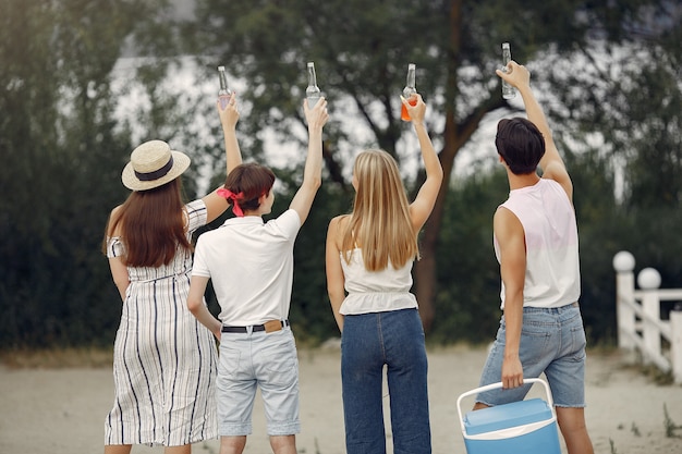 Los amigos se divierten en la playa con bebidas