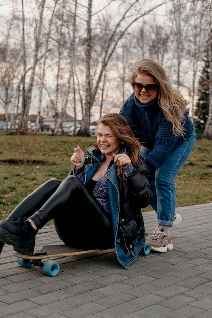 Amigos divirtiéndose al aire libre con patinetas