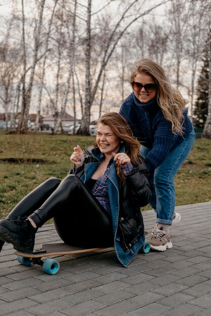 Amigos divirtiéndose al aire libre con patinetas