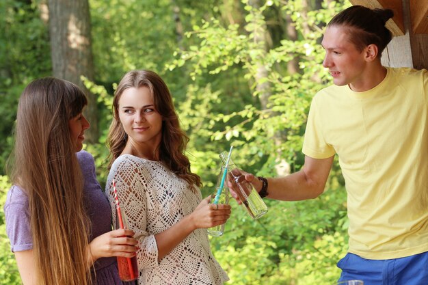 Amigos divirtiéndose y bebiendo en el campamento.