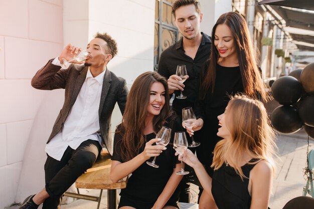 Amigos divirtiéndose y bebiendo champán al aire libre