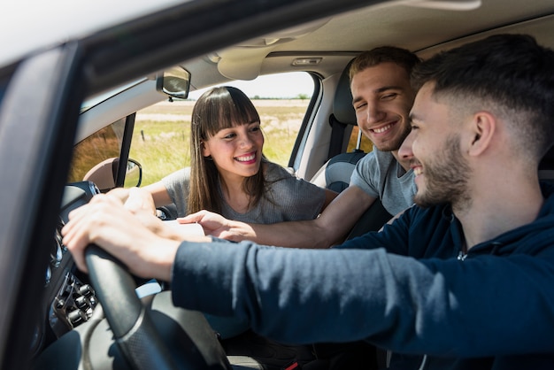 Amigos divirtiéndose dentro del coche