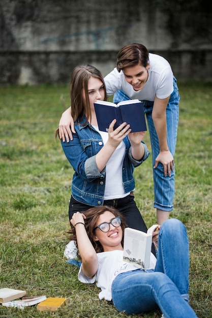 Amigos divirtiéndose con libros en el parque