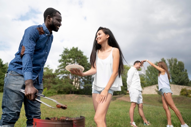 Amigos divirtiéndose mientras hacen una barbacoa