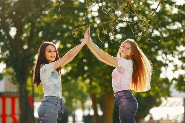 amigos divirtiéndose en un parque con pinturas holi