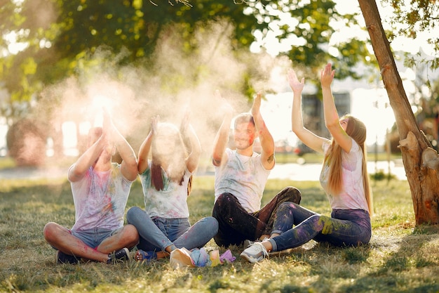 amigos divirtiéndose en un parque con pinturas holi