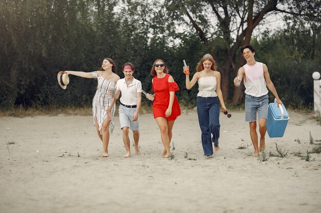 Amigos divirtiéndose en una playa con bebidas