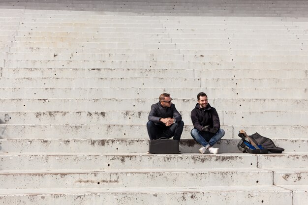 Amigos esperando en escalera de cemento