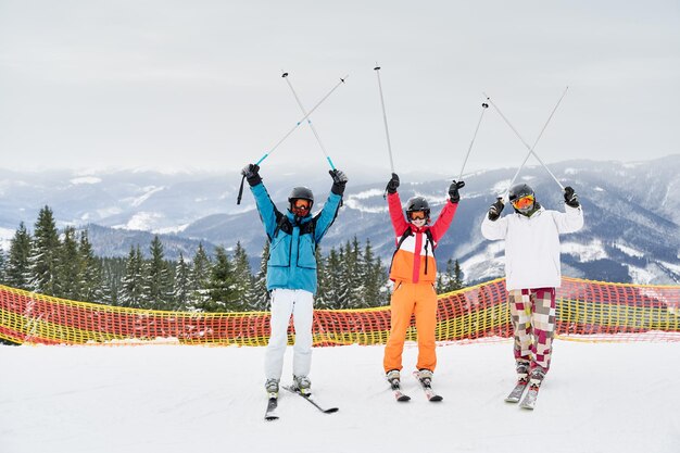 Amigos esquiadores divirtiéndose en la estación de esquí en las montañas en invierno esquiando y haciendo snowboard