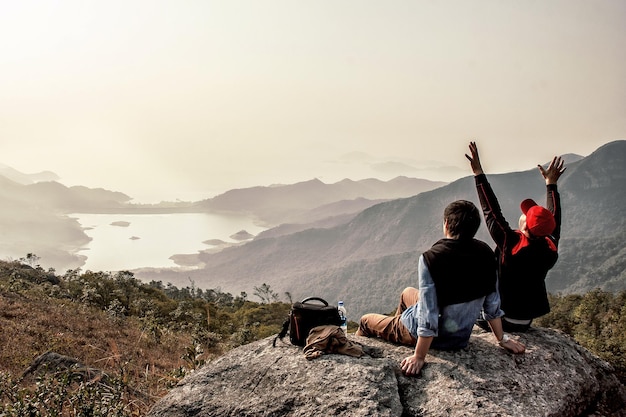 Los amigos están descansando después de subir a la montaña.