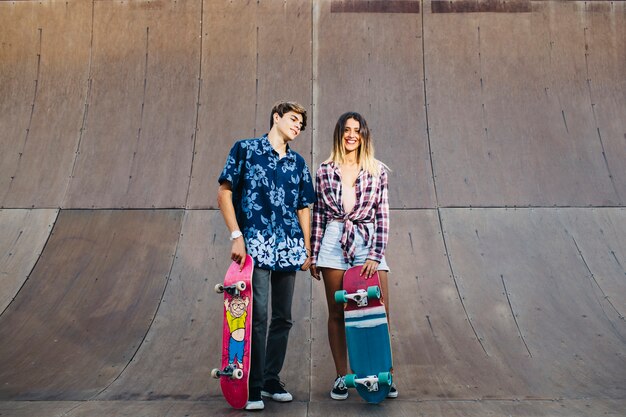 Amigos con estilo posando con patinetas