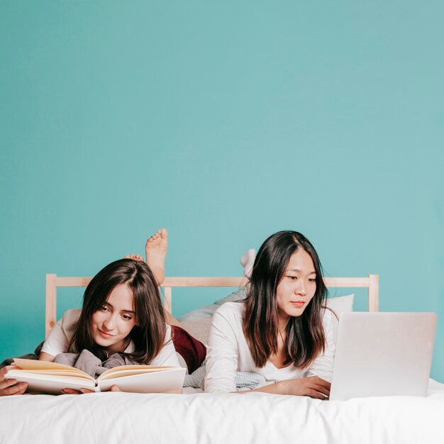 Amigos estudiando en la cama