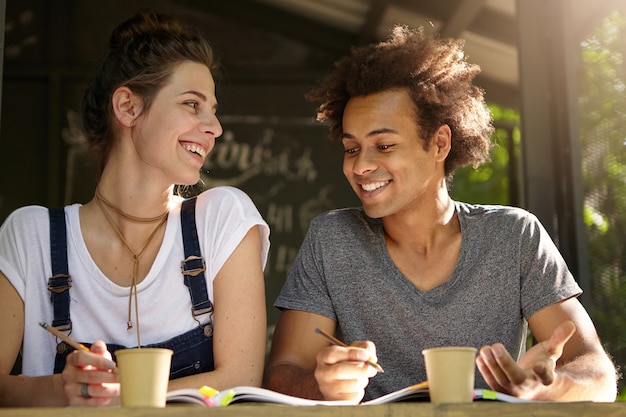 Amigos estudiando juntos en la cafetería