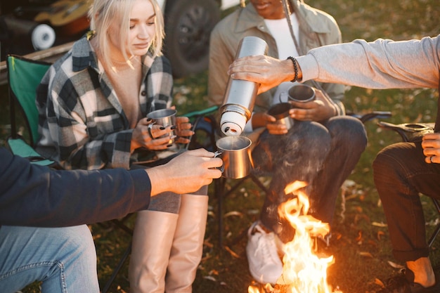 Amigos de etnia europea, negra y musulmana haciendo un picnic