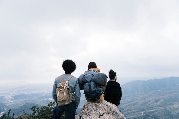 Amigos excursionistas exitosos disfrutan de la vista en el pico de la montaña