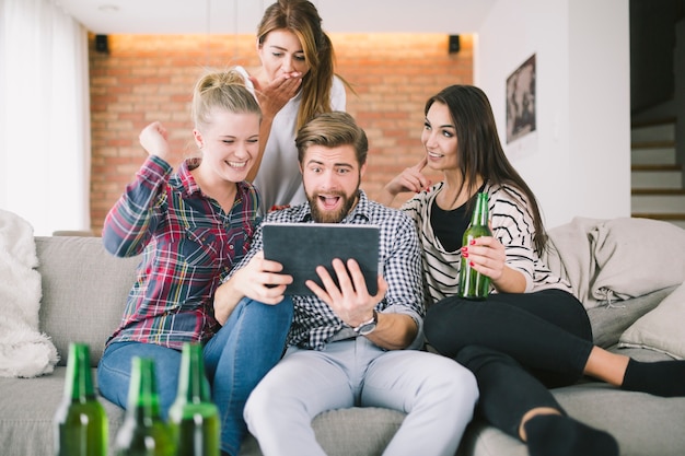 Amigos expresivos haciendo muecas para selfie teniendo fiesta