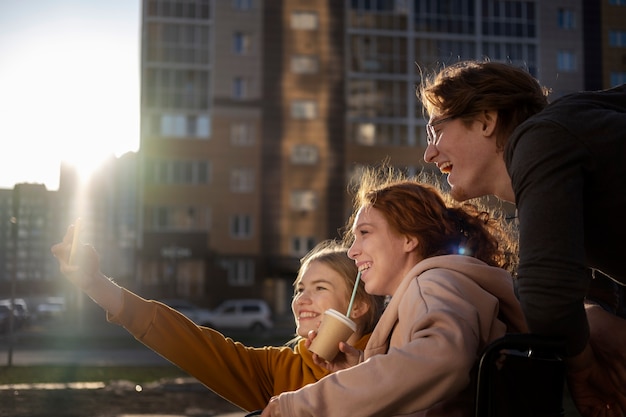 Foto gratuita amigos felices al aire libre tomando selfie vista lateral