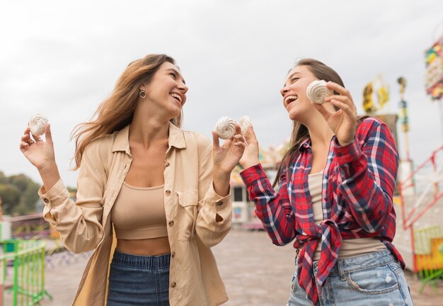 Amigos felices de ángulo bajo con dulces