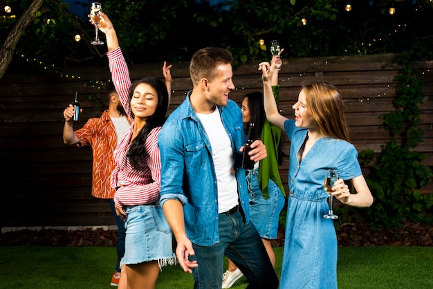 Amigos felices bailando juntos con bebidas