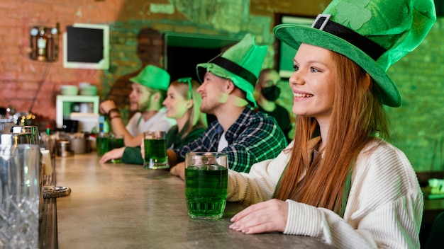 Amigos felices celebrando st. día de patrick junto con bebidas