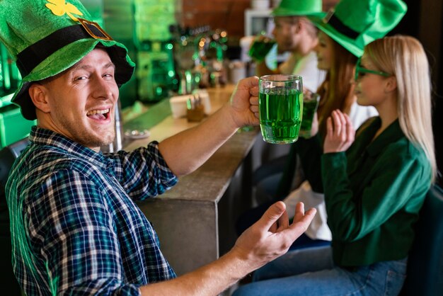 Amigos felices celebrando st. patrick's day juntos en el bar