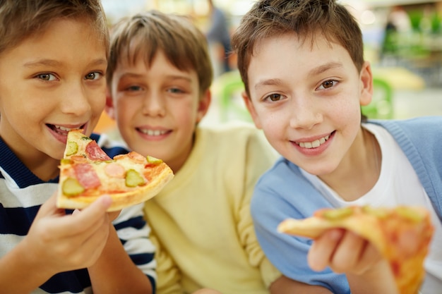 Amigos felices comiendo una pizza