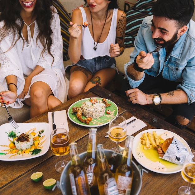 Foto gratuita amigos felices comiendo tapas