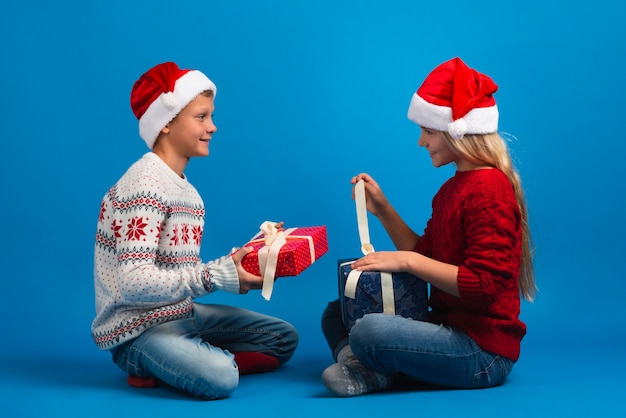 Amigos felices desenvolviendo regalos de navidad