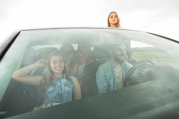 Foto gratuita amigos felices disfrutando en el coche