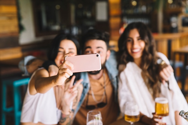 Amigos felices haciendo un selfie en bar