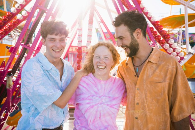 Amigos felices en el parque de atracciones abrazándose