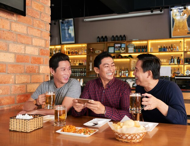 Amigos felices pasando tiempo juntos en un pub de cerveza